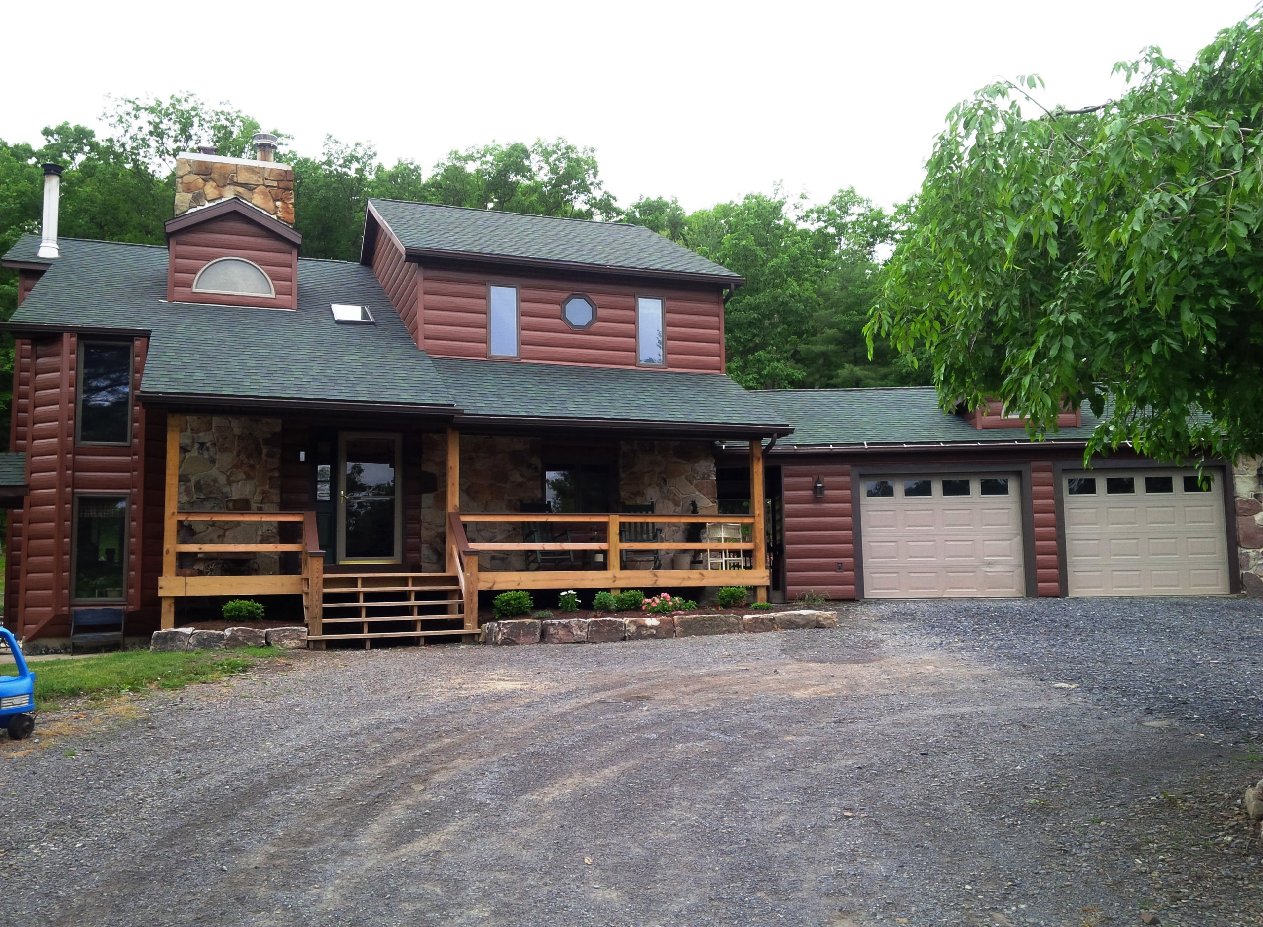 Rustic home exterior with steel log siding and stone accents