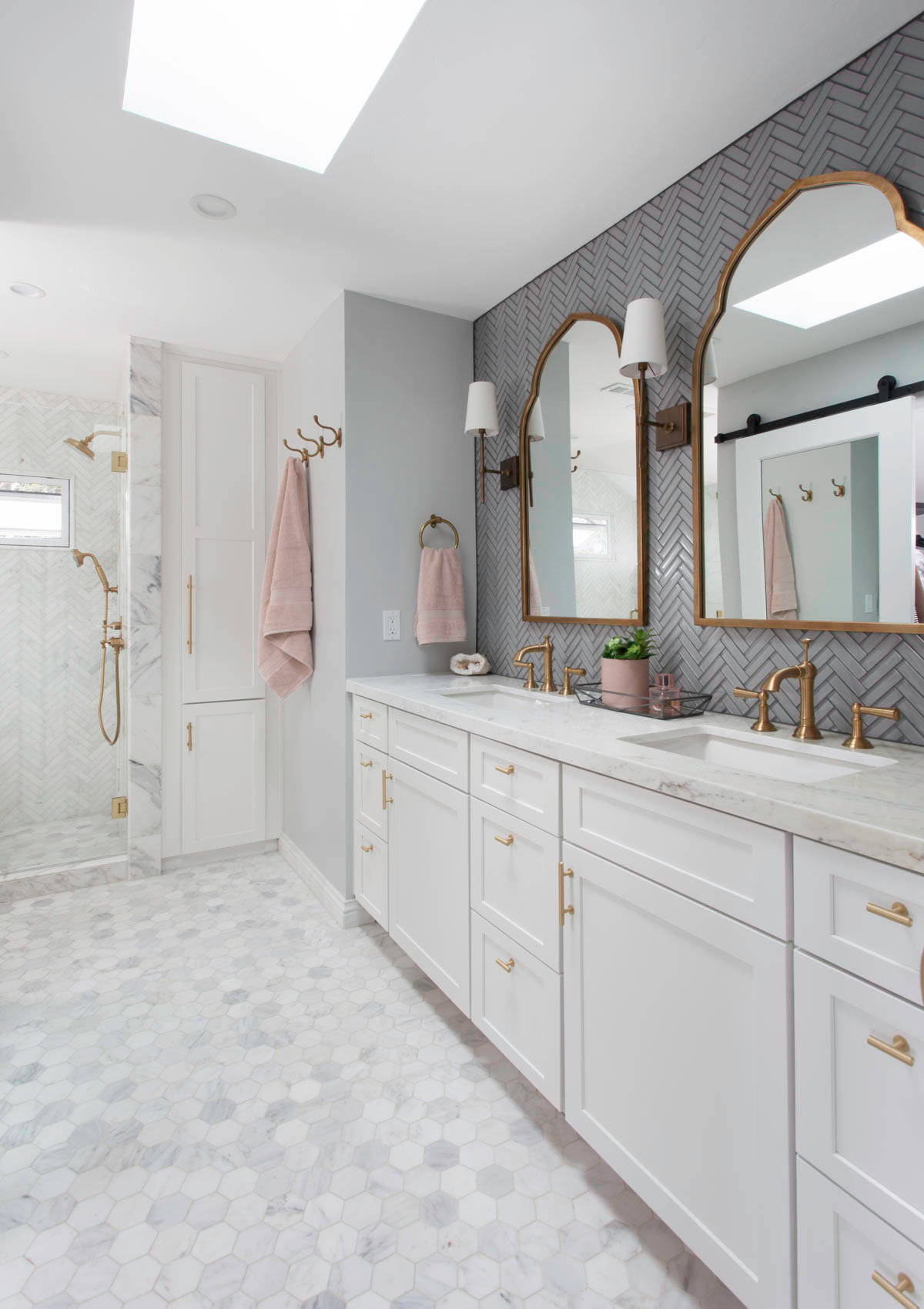 Elegant marble master bathroom with gold fixtures and dual vanity.