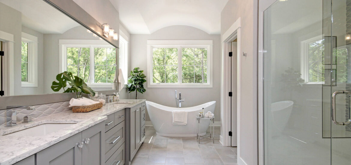 Elegant bathroom with freestanding tub, large vanity, and glass-enclosed shower.