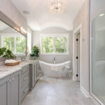 Elegant bathroom with freestanding tub, large vanity, and glass-enclosed shower.