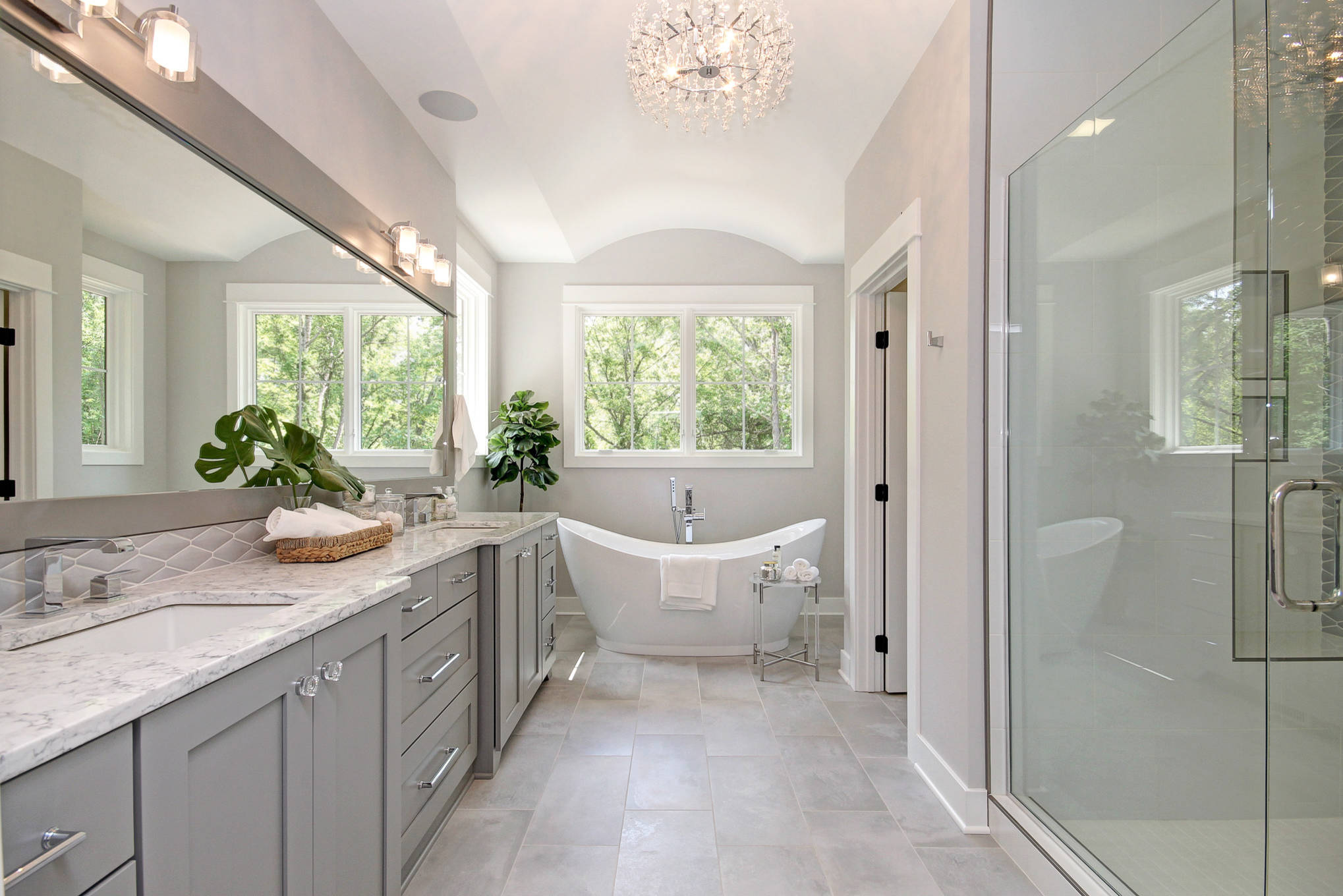 Elegant bathroom with freestanding tub, large vanity, and glass-enclosed shower.