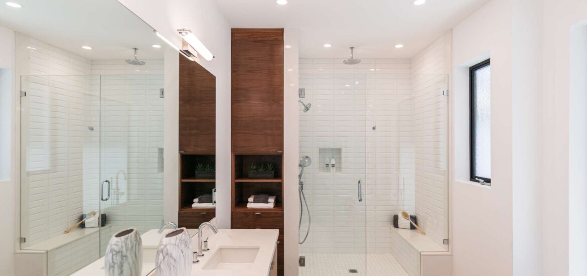 Modern bathroom with double shower, wooden cabinetry, and freestanding bathtub.