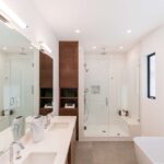 Modern bathroom with double shower, wooden cabinetry, and freestanding bathtub.