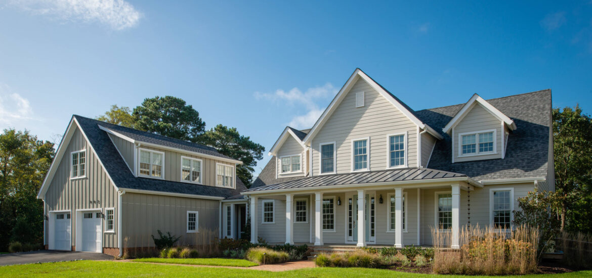 Modern farmhouse with light gray siding, white trim, and detached garage