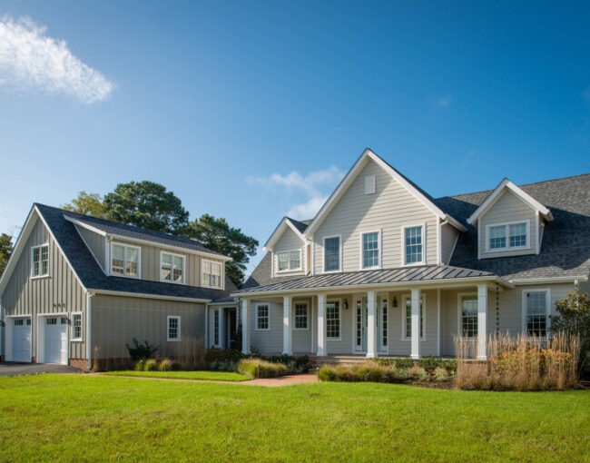 Modern farmhouse with light gray siding, white trim, and detached garage