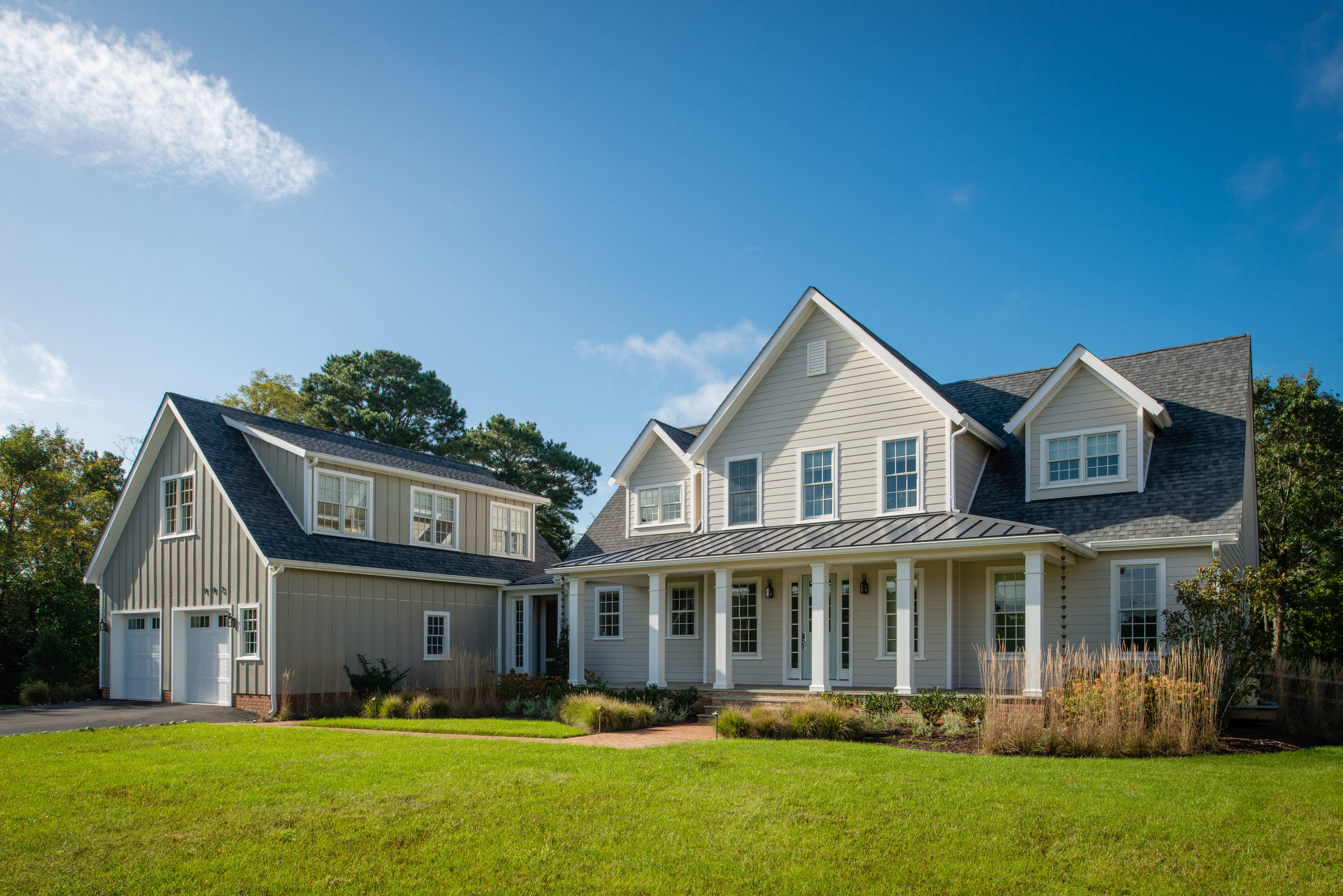 Modern farmhouse with light gray siding, white trim, and detached garage