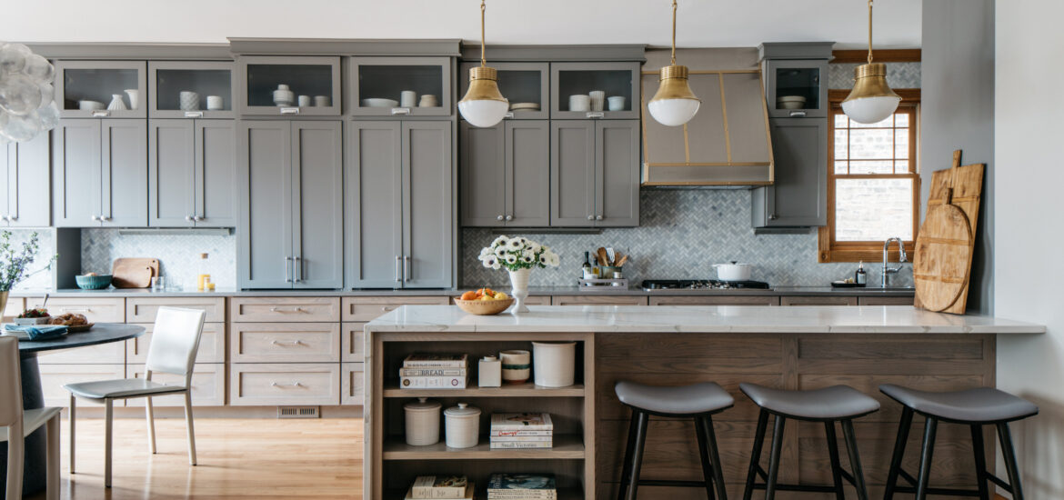 Modern kitchen with gray cabinets, marble island, and pendant lighting