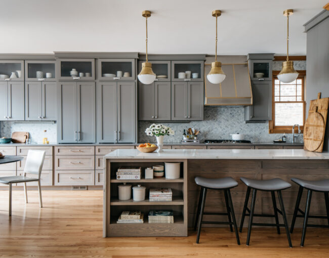 Modern kitchen with gray cabinets, marble island, and pendant lighting