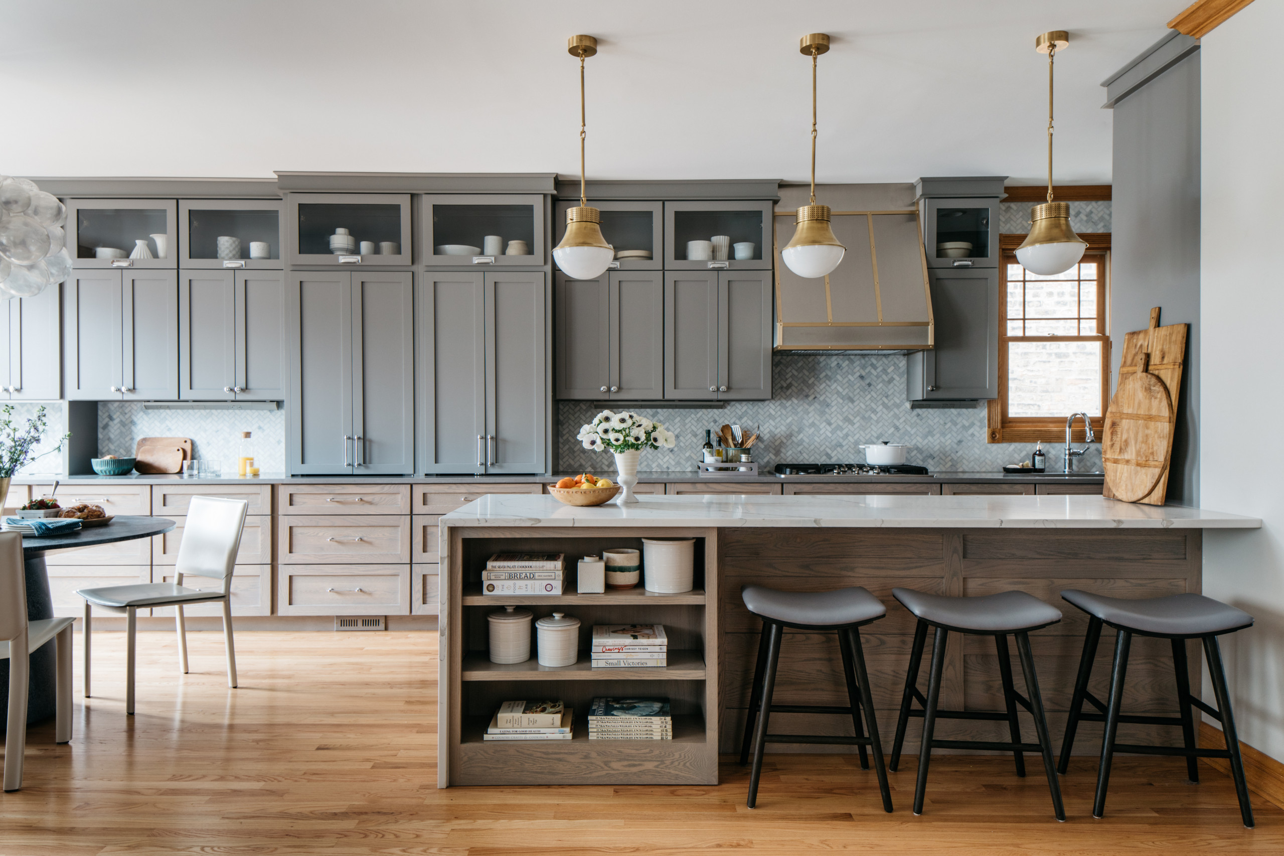 Modern kitchen with gray cabinets, marble island, and pendant lighting