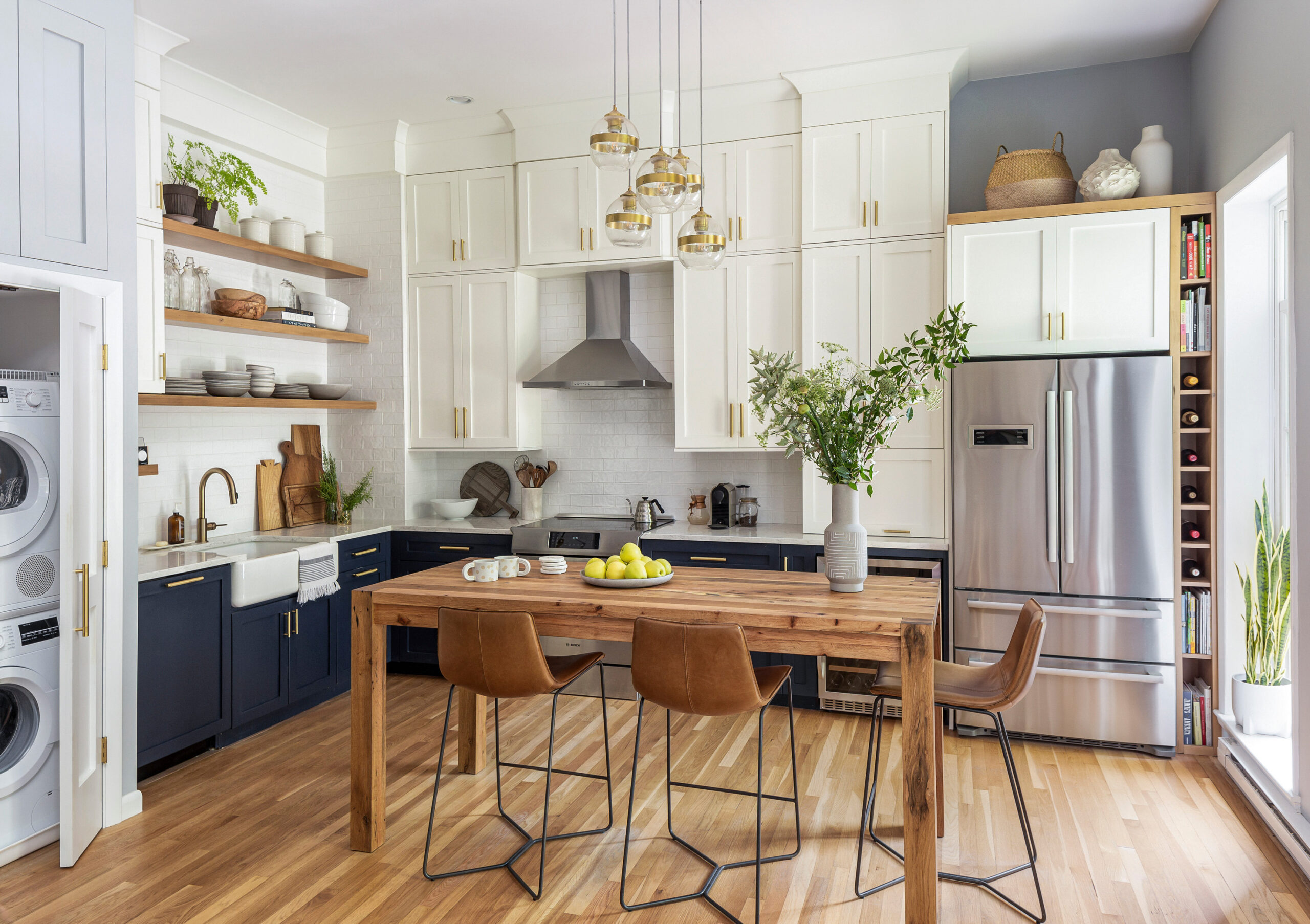 Bright kitchen with two-tone cabinetry, wood accents, and a rustic dining table.