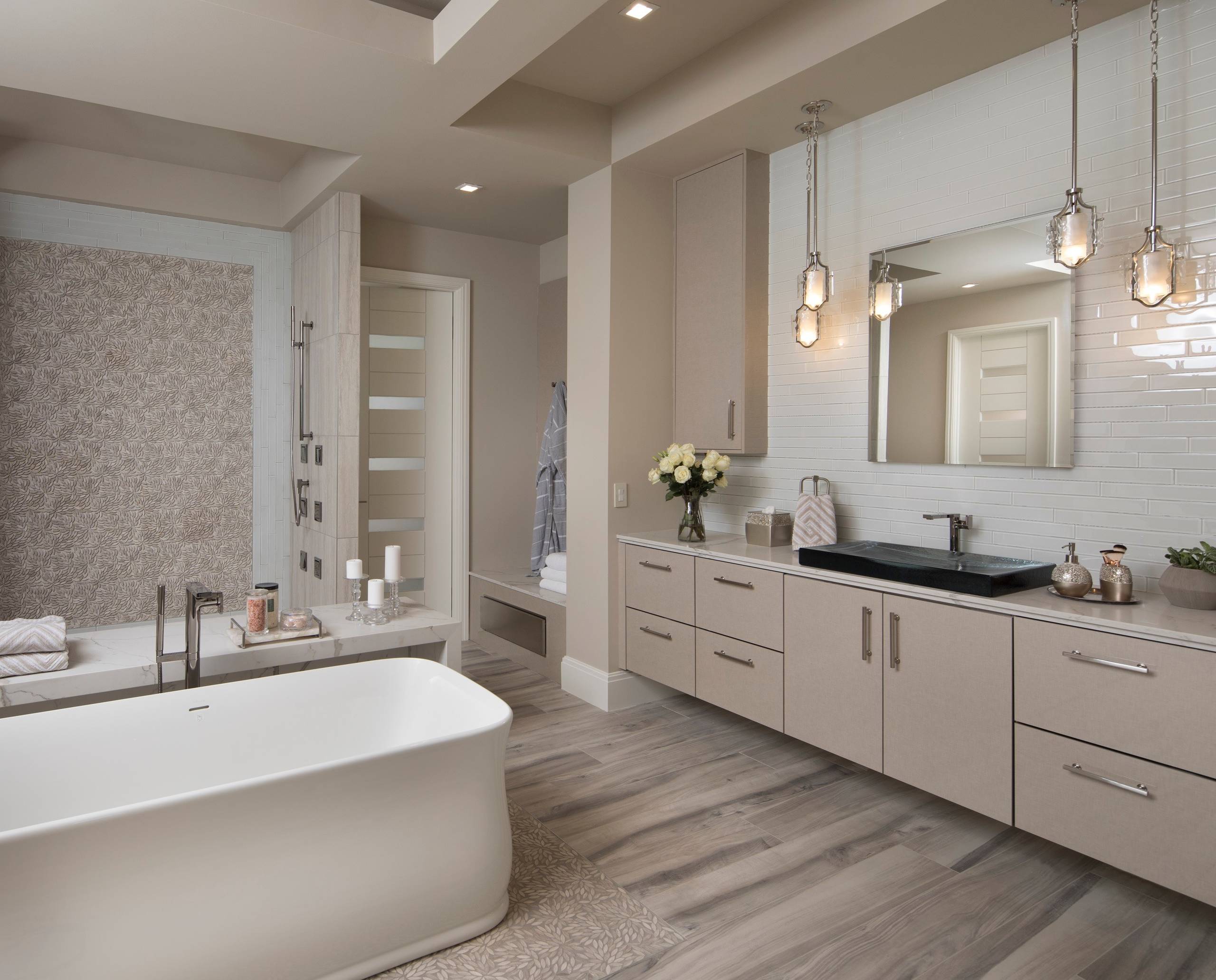 Elegant bathroom with freestanding tub, modern vanity, and pendant lighting.