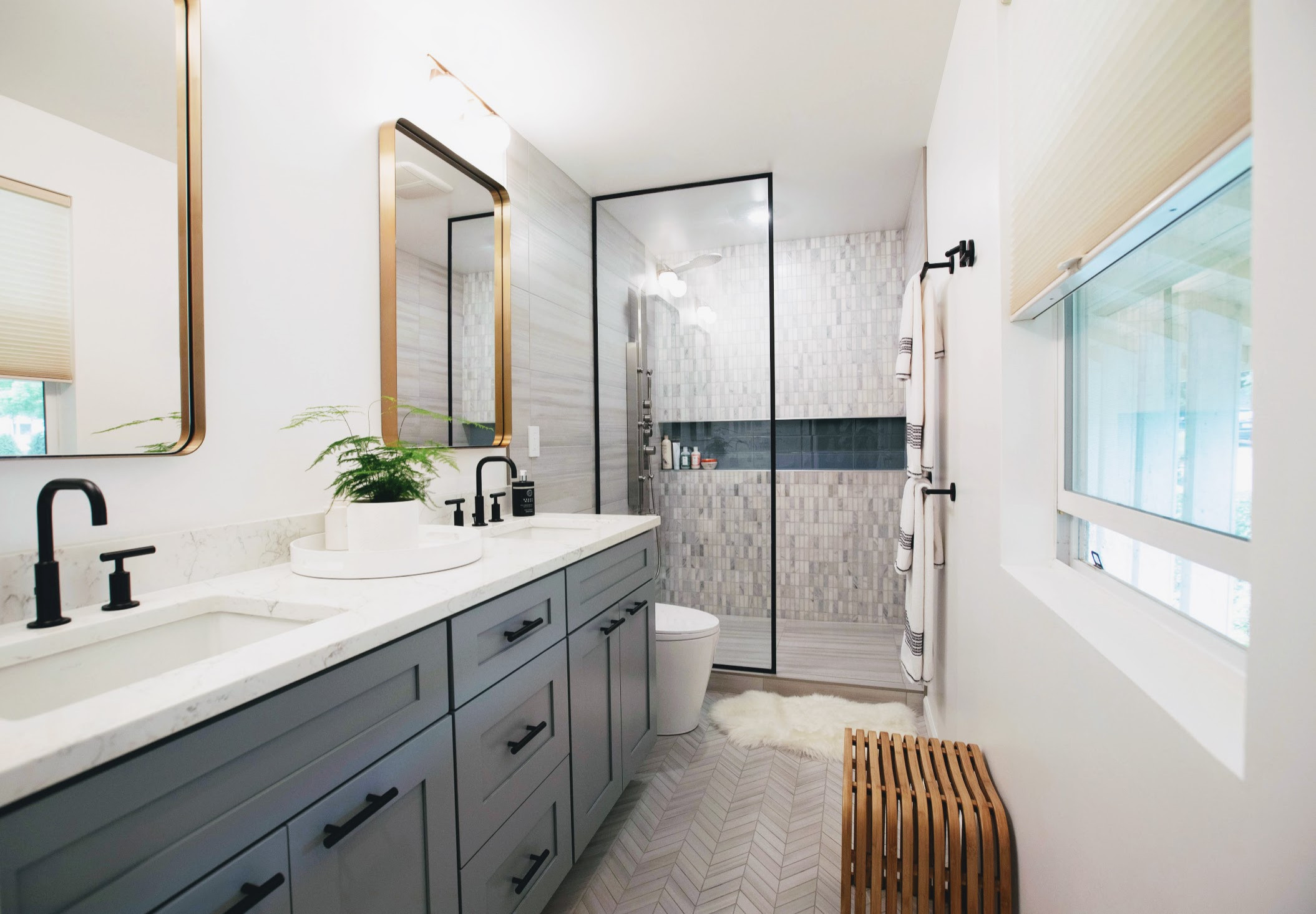 Modern transitional bathroom with double vanity and glass-enclosed shower.