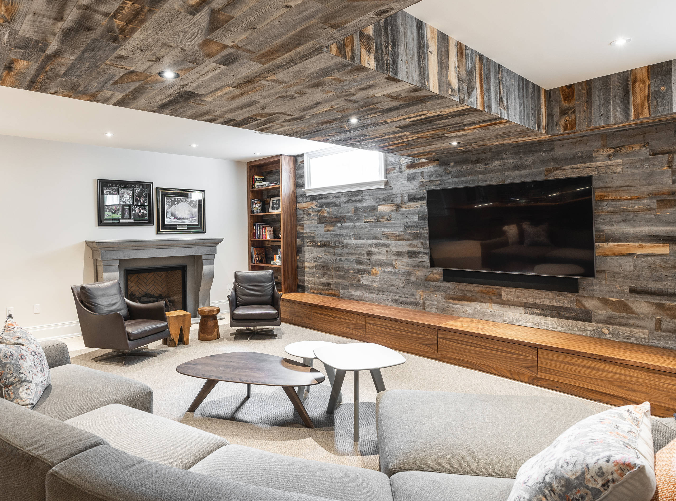 Basement living room with rustic wood accent wall and ceiling