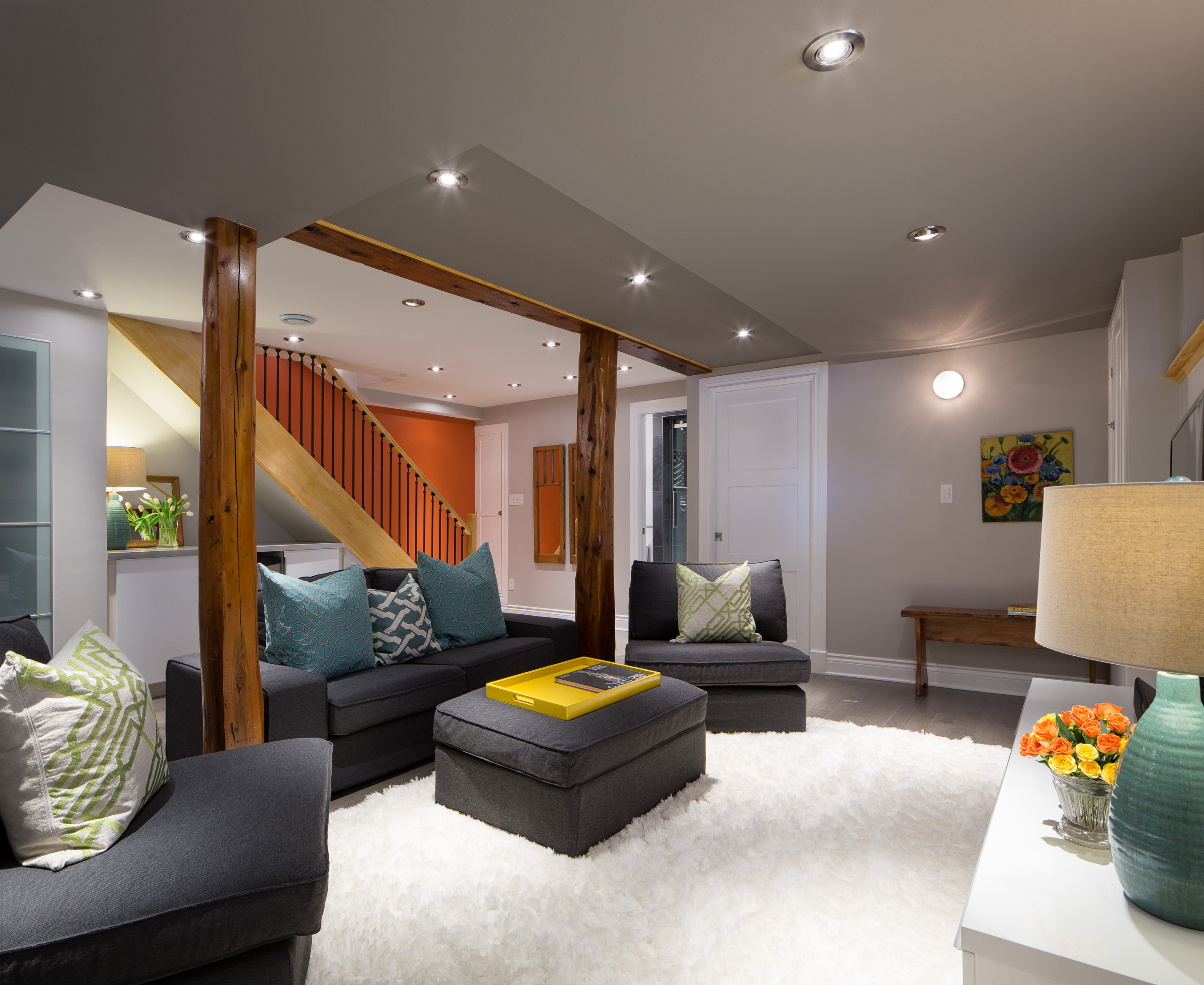 Modern basement living room with cozy seating and wooden beams