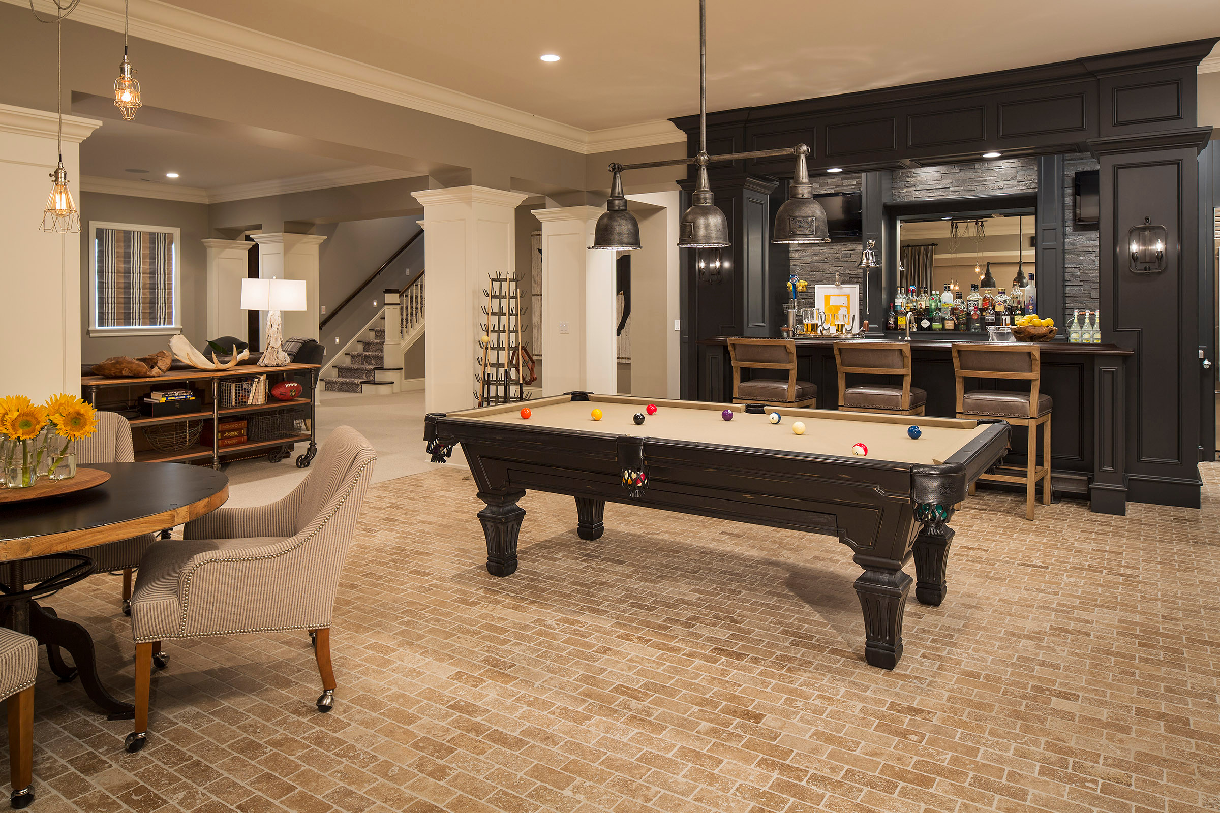 Luxury basement with pool table, bar area, and elegant seating.