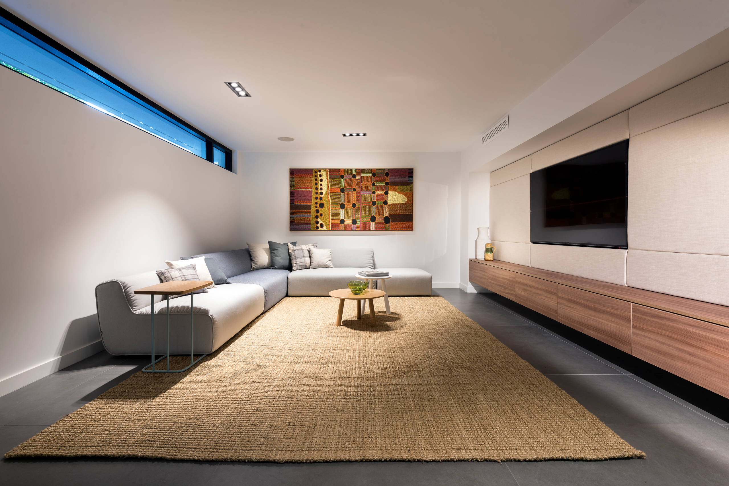 Modern minimalist living room with sectional sofa and wall-mounted TV