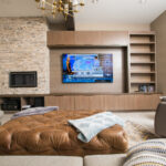 Basement living room with stone accent wall and modern shelving