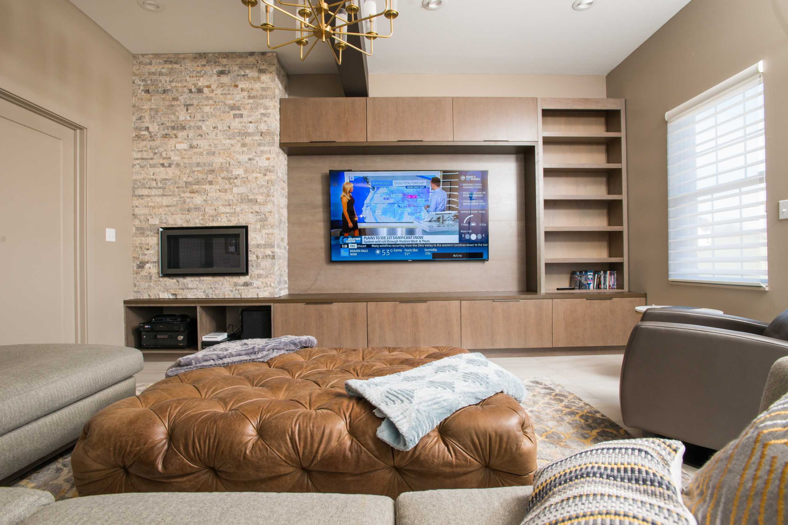 Basement living room with stone accent wall and modern shelving